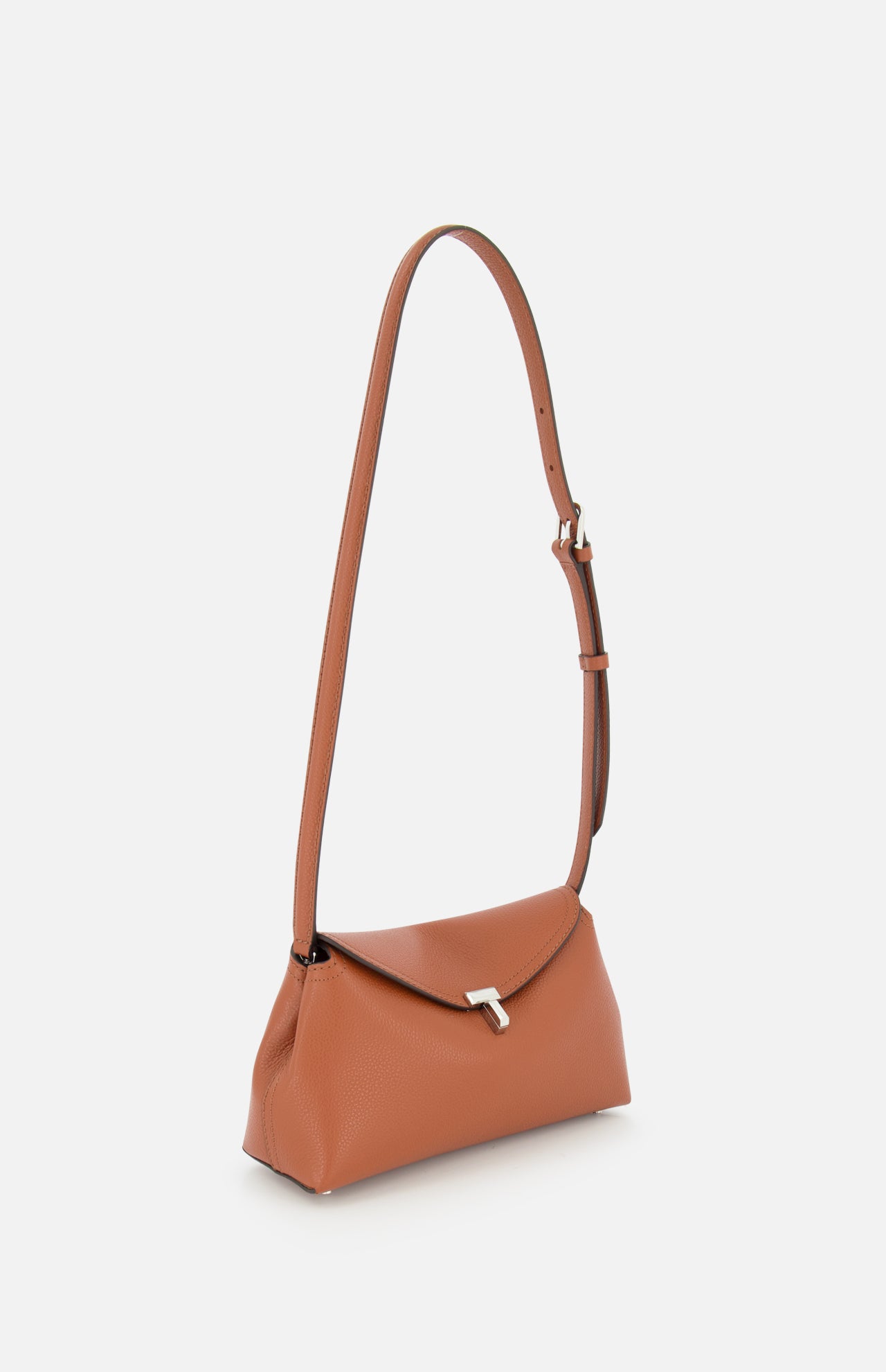 The TOTEME T-Lock Grained-Leather Clutch Bag, crafted in Italy from tan leather, features a silver clasp, long adjustable strap, and a structured rectangular shape, shown on a white background.