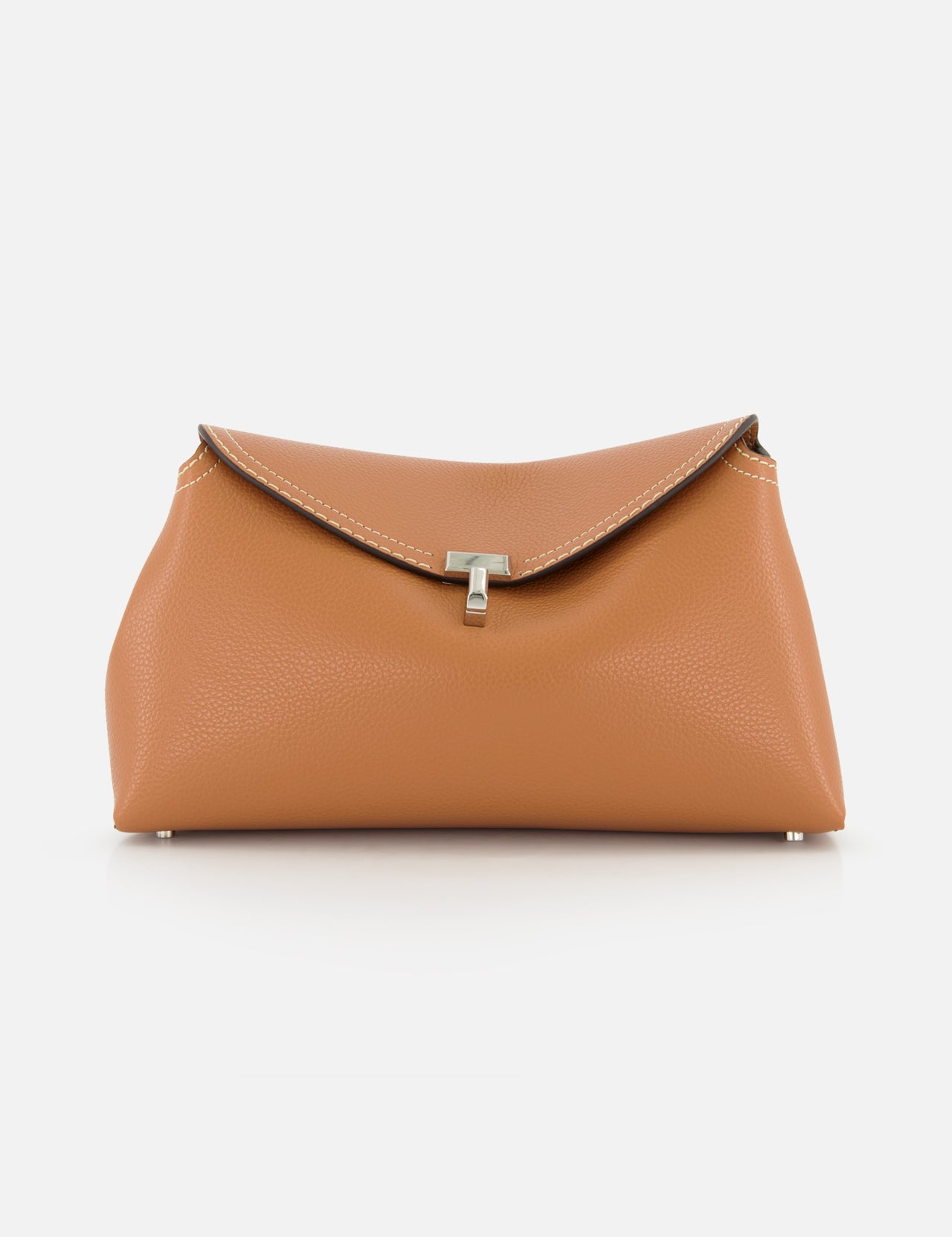 The TOTEME T-Lock Grained-Leather Clutch is an Italian-made tan leather bag featuring a flap closure, white stitching, and a central silver clasp, shown against a plain white background.