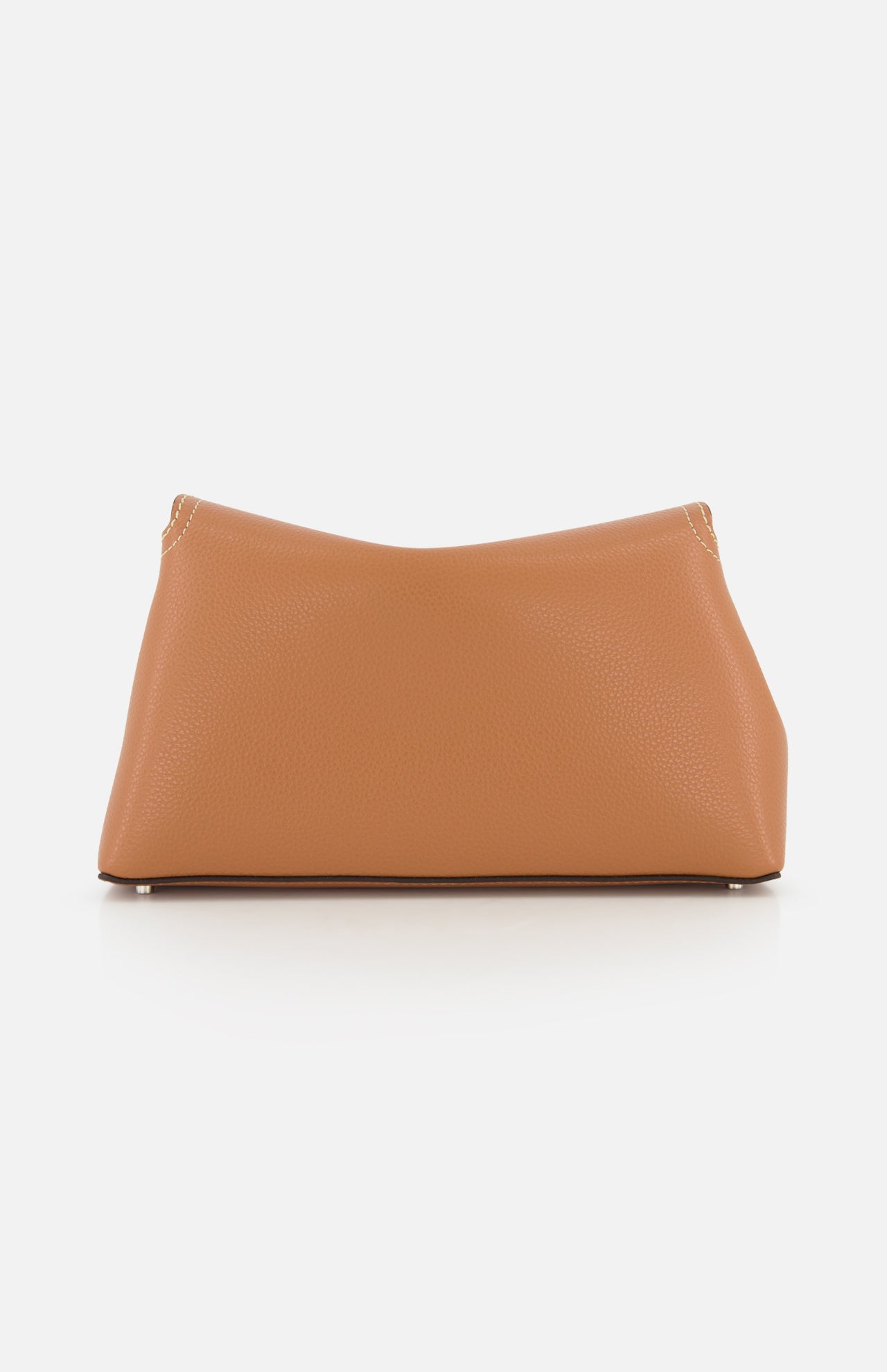The TOTEME T-Lock Grained-Leather Clutch is a medium-sized, sculptural tan leather bag with a softly curved rectangular shape and visible top-corner stitching, shown on a plain white background.