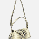 The TOTEME T-Lock Python Embossed Shoulder Bag is crafted from beige snake-effect leather with a bold black snakeskin pattern, featuring a top handle and an adjustable shoulder strap, and is displayed against a plain white background.