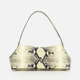 The TOTEME T-Lock Python Embossed Shoulder Bag is a small, rectangular sculptural shoulder bag featuring a single strap and a beige and black python-embossed pattern, crafted from luxurious snake-effect leather in Italy, and displayed against a plain white background.