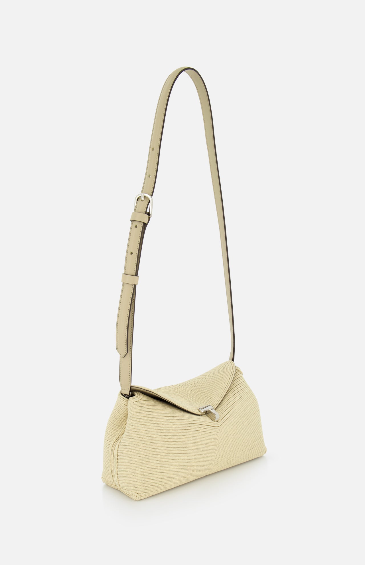 The TOTEME T-Lock Rope Clutch is a beige textured shoulder bag with an artisanal rope detail, long adjustable strap, silver buckle, and flap closure, shown on a plain white background.