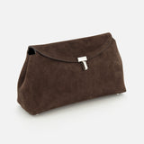 The TOTEME T-Lock Suede Clutch, a chocolate brown sculptural bag with a silver clasp crafted in Italy, stands upright on a white background.