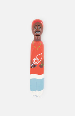 The WEDGIE ‘Twopak’ Wood Door Stopper is a colorful, hand-painted figurine with a brown face, red shirt, gold necklace, blue shorts, and white shoes—ideal as Tupac-inspired decor for any space.