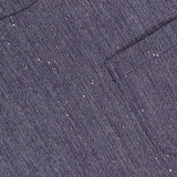 Close-up of the TWP Ex Cropped Sequin Denim T Shirt reveals blue textured fabric with speckled details, a round neckline, chest pocket, and cropped boxy silhouette—hallmarks of modern women's workwear.