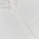Close-up of the TWP J.D. Shirt—a women's white shirt with thin red vertical stripes, front pocket, and a visible collar label, offering a classic striped workwear style.