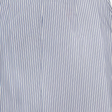 Close-up of the TWP Striped A-Line Skirt, featuring white cotton fabric with vertical blue pinstripes. The image highlights the waistband and upper section of this classic women’s piece.