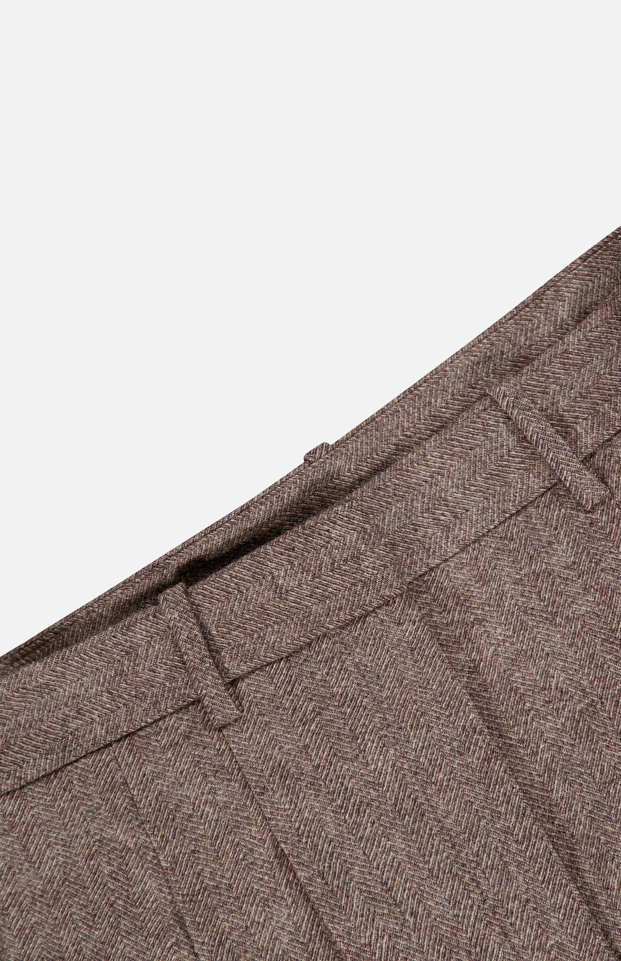 Close-up of the waistband and pleats of the Avery Wide Leg Trouser Pant by TWP in a brown herringbone pattern, highlighting the belt loops and rich fabric texture against a plain white background. These wide-leg trousers offer a sophisticated touch to women’s workwear.