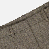 Close-up of the Avery Herringbone Wide Leg Trouser by TWP in brown wool, highlighting the waistband, belt loops, and pleats against a white background—a refined reimagining of women’s workwear. These wide-leg trousers blend classic tailoring with contemporary elegance.