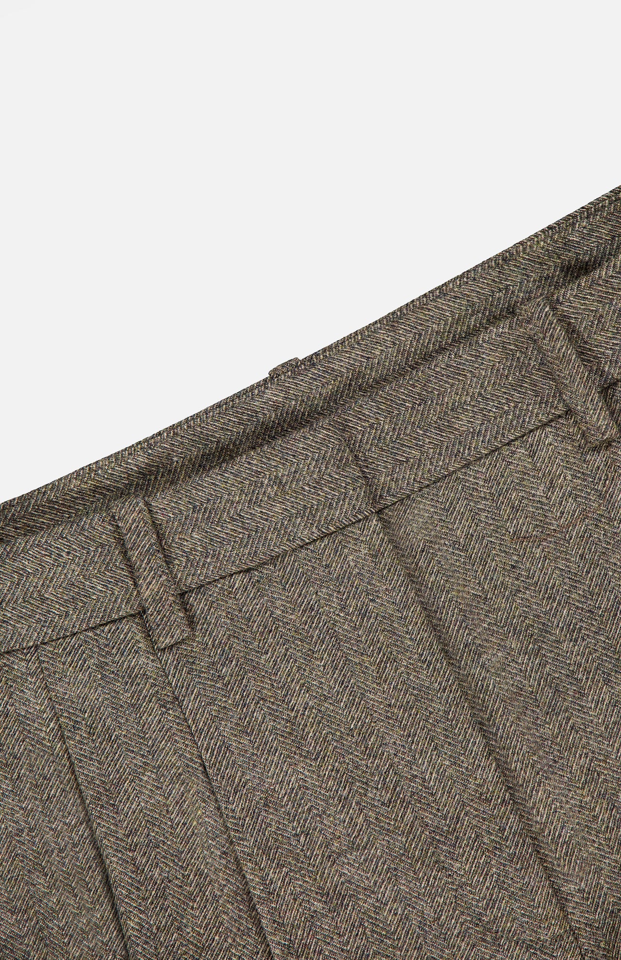 Close-up of the Avery Herringbone Wide Leg Trouser by TWP in brown wool, highlighting the waistband, belt loops, and pleats against a white background—a refined reimagining of women’s workwear. These wide-leg trousers blend classic tailoring with contemporary elegance.
