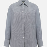 The TWP Big Joe Glossy Stripe Shirt is a women's oversized, long-sleeve button-up in light gray with subtle vertical stripes, a chest pocket, and classic collar—ideal for workwear and shown on a white background.
