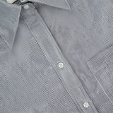 Close-up of the Big Joe Glossy Stripe Shirt by TWP, a black and white pinstriped button-up for women featuring white buttons and a visible TWP XS collar tag—ideal as stylish workwear.