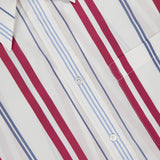Close-up of the TWP Big Joe Oversized Shirt, featuring red and light blue vertical stripes on white, a chest pocket, and a pointed collar.