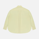 Back view of the Big Joe Oversized Shirt by TWP, a pale yellow cotton-silk blend long-sleeve button-up with a curved hem and buttoned cuffs, shown against a white background.