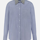 The TWP Big Joe with Crystal Collar Shirt is a light blue women’s long-sleeve button-up workwear shirt featuring a single chest pocket and a sparkly, textured silver crystal collar, shown against a plain white background.