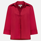 The Deep V Relaxed Shirt by TWP is a red, long-sleeve, button-up shirt with a collar and folded cuffs, made from Italian superfine cotton. Shown on a white background, the label inside reads TWP.