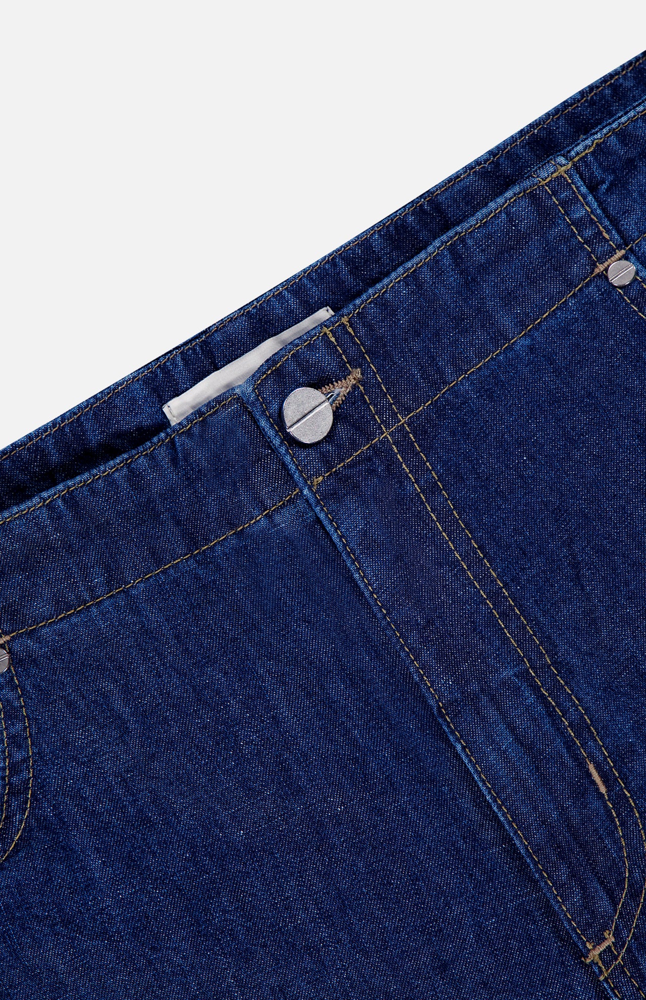 Close-up of the waistband and upper front of TWP Dillon Denim Jeans in Dark Stone, highlighting a metal button, belt loops, and yellow stitching—ideal for women's workwear.