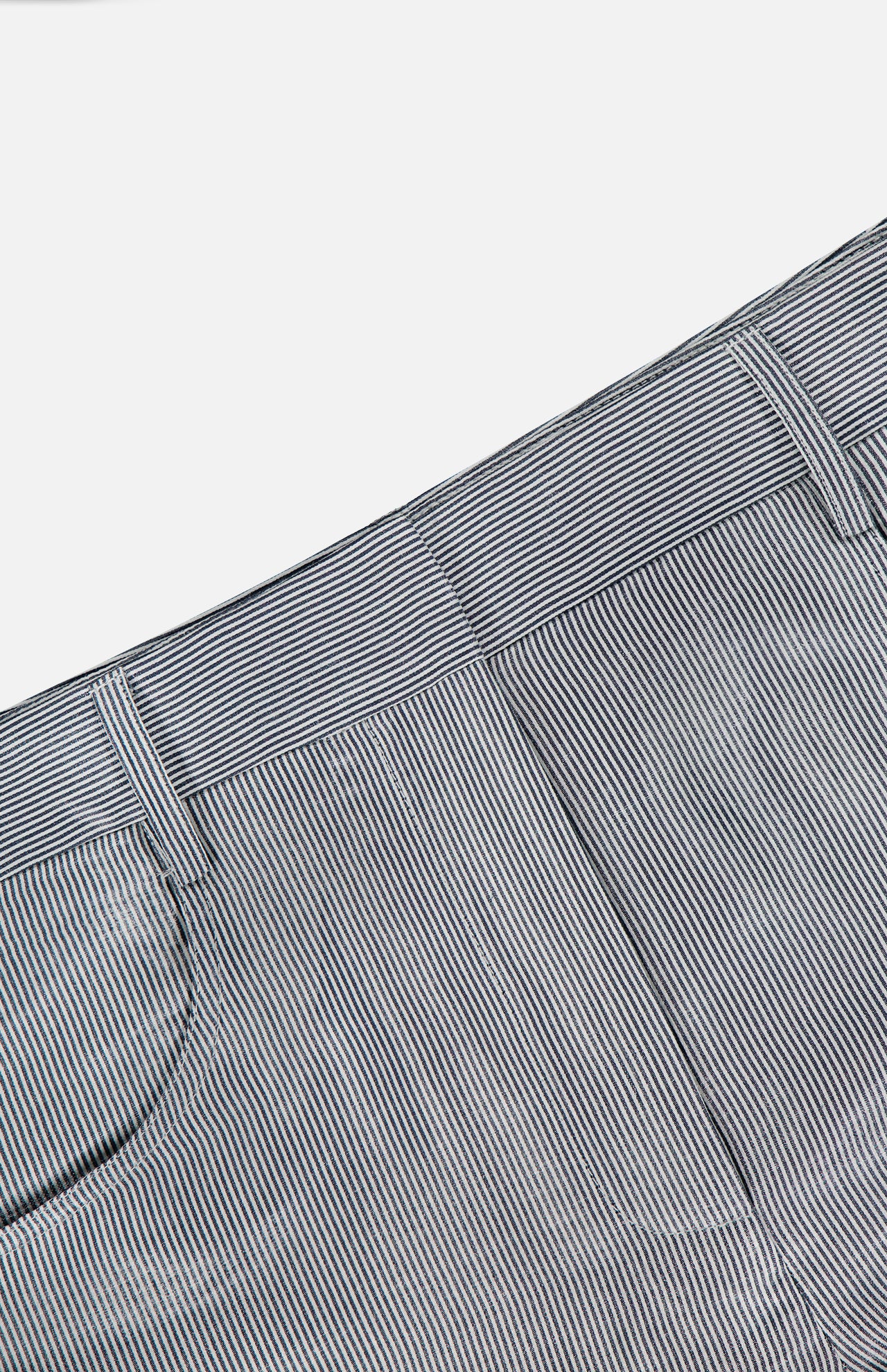 Close-up of TWP Dillon Glossy Stripe Pants in blue and white vertical stripes, featuring belt loops, a pocket, and a waistband—these high-rise wide-leg pants are an ideal choice for stylish women's workwear.