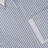 Close-up of the TWP Double Layer Boyfriend Shirt, showcasing a white dress shirt with thin blue vertical stripes, a crisp white collar, and part of a pocket visible.