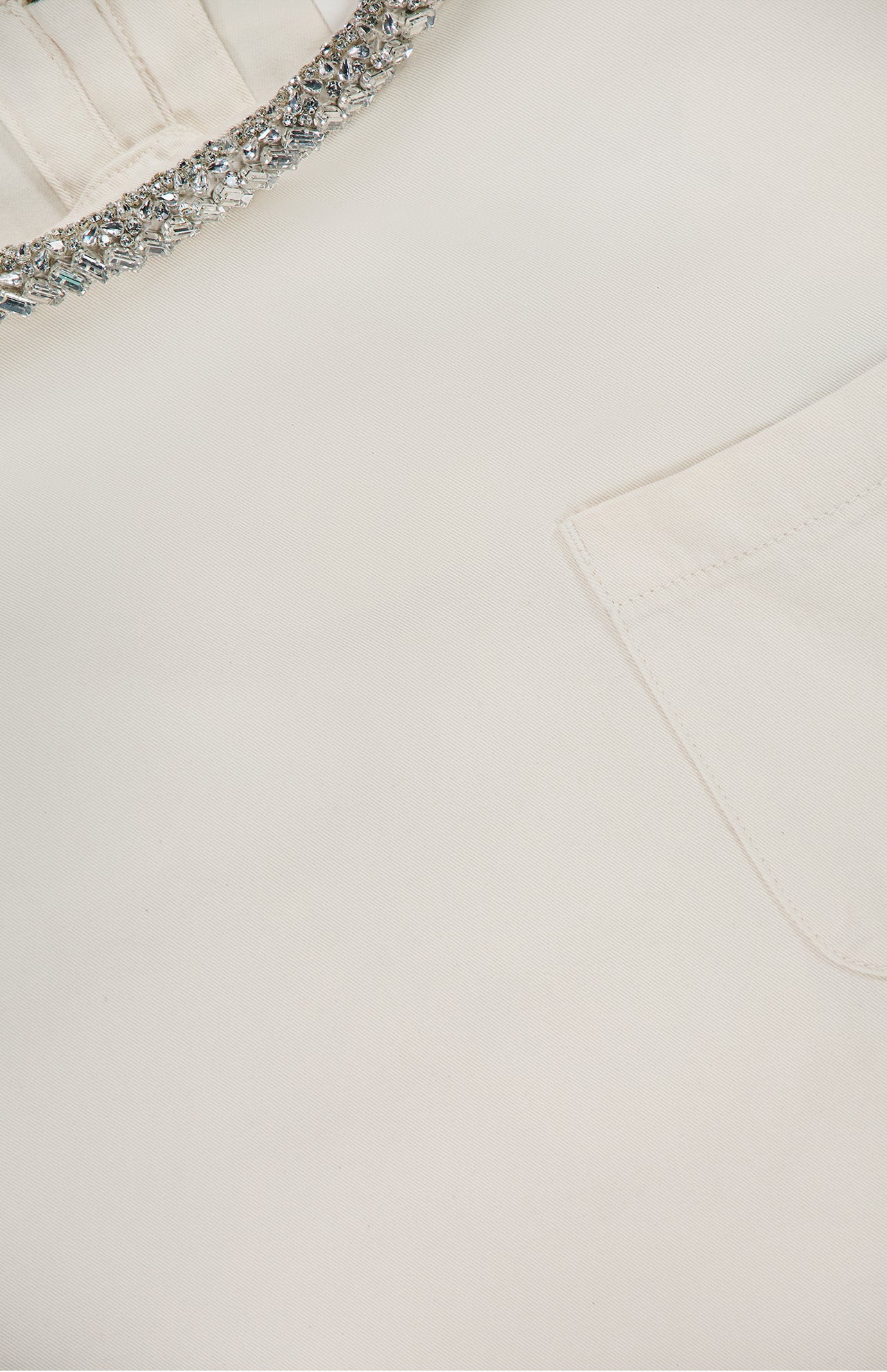 Close-up of the TWP Ex T Shirt With Crystal Collar: a white cropped cotton women’s workwear top featuring a visible chest pocket and a sparkling beaded crystal-embellished collar.