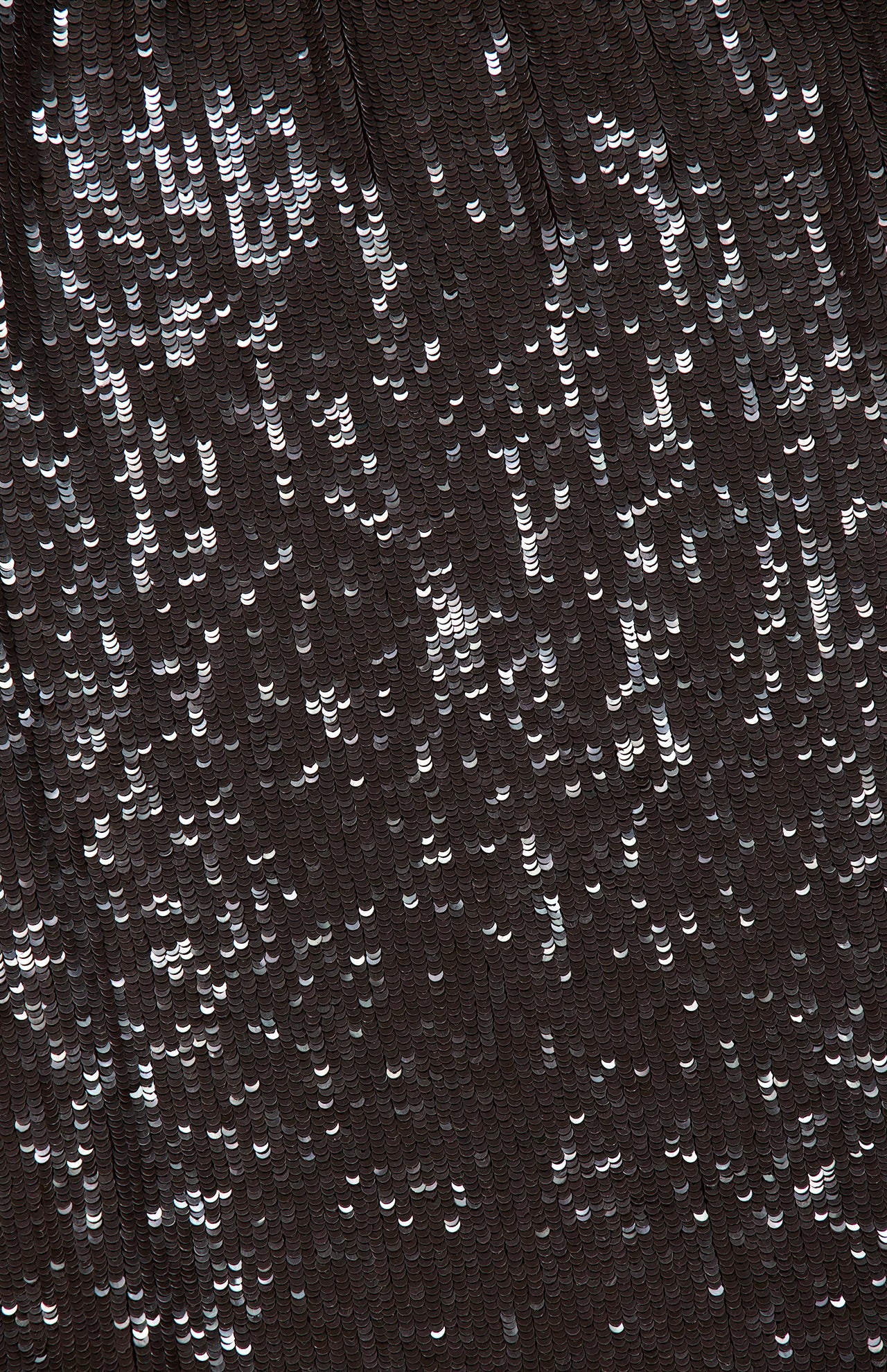 Close-up of the Friday Night Top, a dark, backless sequin halter top densely covered in shimmering, reflective sequins.