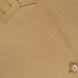 Close-up of the TWP Fringe Benefit Jacket shows its water-repellent fabric, detailed stitching, collar with buttonholes, and two light-colored buttons. The material's texture is clearly visible.