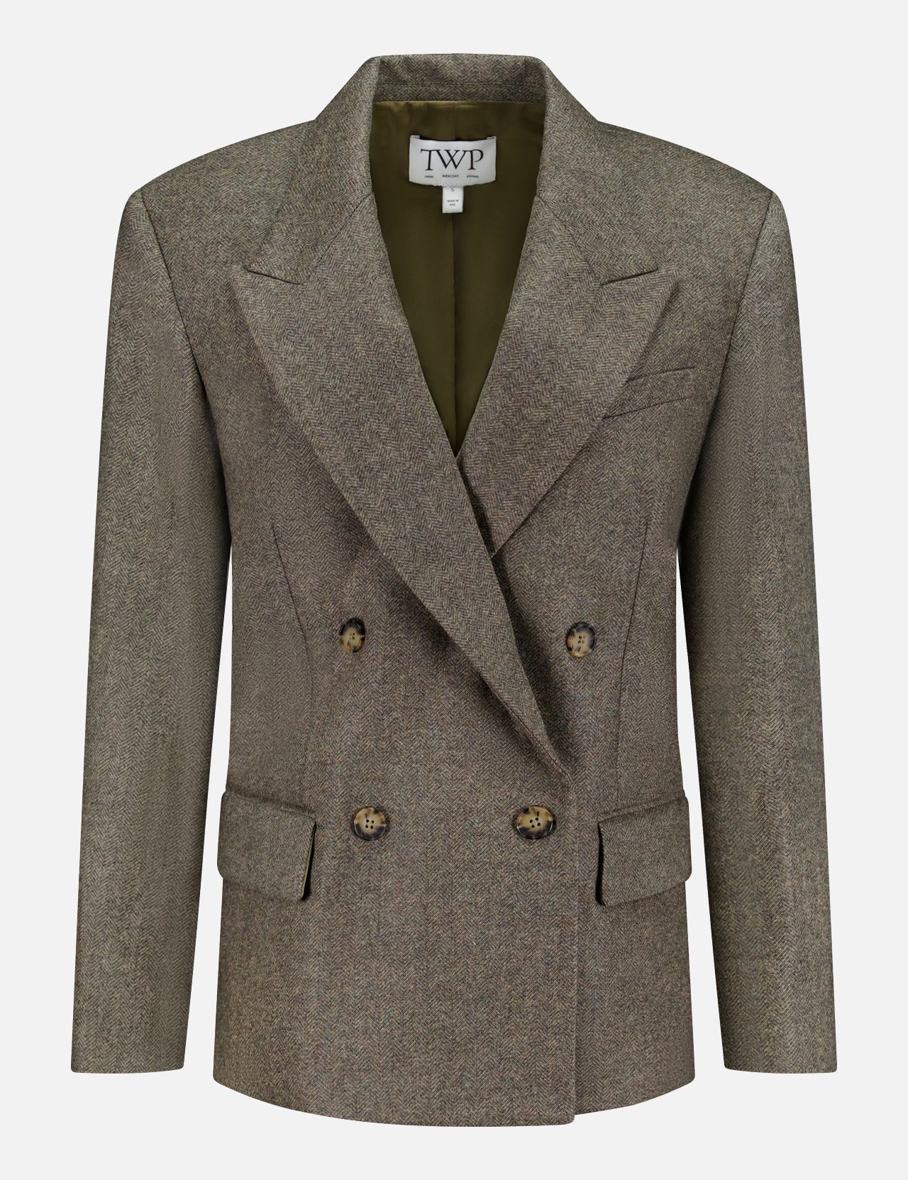 A double-breasted, olive-green wool blazer—the Harper Herringbone Blazer by TWP—features peaked lapels, four buttons, flap pockets, and a TWP label inside the collar, offering a sophisticated alternative to the classic women's grey blazer or herringbone workwear jacket.