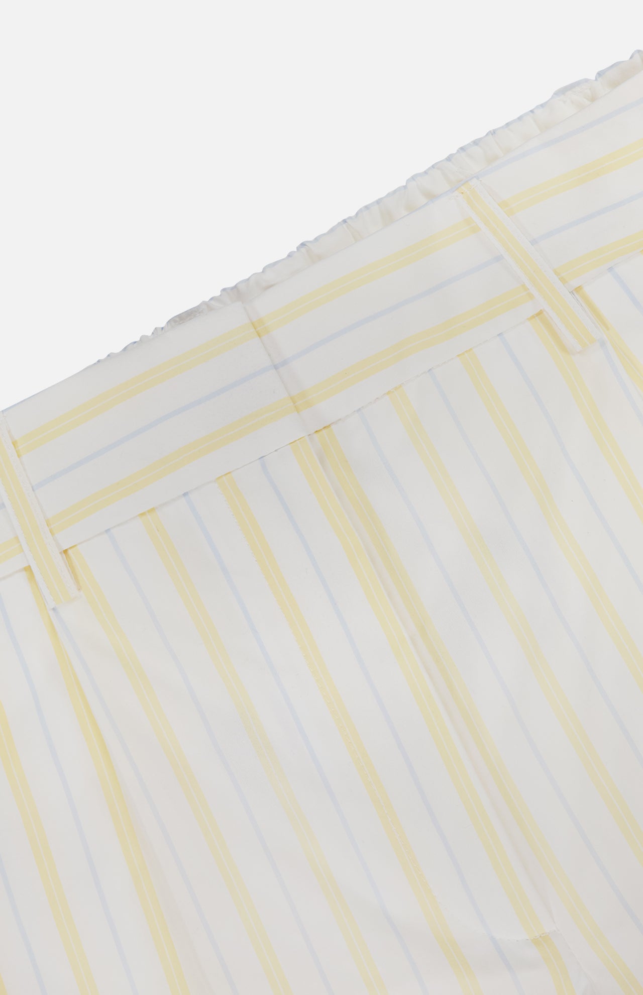 Close-up of TWP's Henry St Striped Shorts, showcasing vertical yellow and light blue stripes on white fabric with an elastic waistband and belt loops.