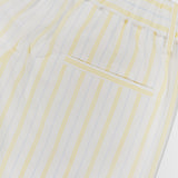 The Henry St Striped Shorts by TWP feature white fabric with light yellow and pale blue stripes, an elastic waistband, single back welt pocket, and a relaxed mid-rise fit inspired by women's workwear shorts.