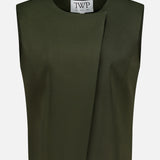 The High Neck Hidden Placket Vest by TWP is a sleeveless, dark olive green cropped top designed in a minimalist style. It features an asymmetrical front fold, round neckline, and a visible white label with the brand’s name inside. Ideal for women seeking refined yet contemporary workwear, this modern vest is photographed against a plain white background.