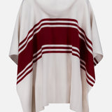 The TWP Hooded Cashmere Stripe Poncho in cream features a hood, two wide and two thin maroon stripes across the back, and pointed sides for a relaxed, stylish drape.