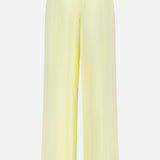 The Hudson St Pleated Pant by TWP is a wide-leg, high-waisted yellow trouser with an elastic waistband and single back pocket, shown from the back on a white background—a relaxed workwear option for women.