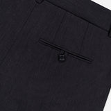 Close-up of the TWP Ivy Pleated Trouser Pant, crafted from dark Italian wool, featuring a waistband with belt loops and a single back pocket with button closure—an ideal choice for refined women’s workwear.