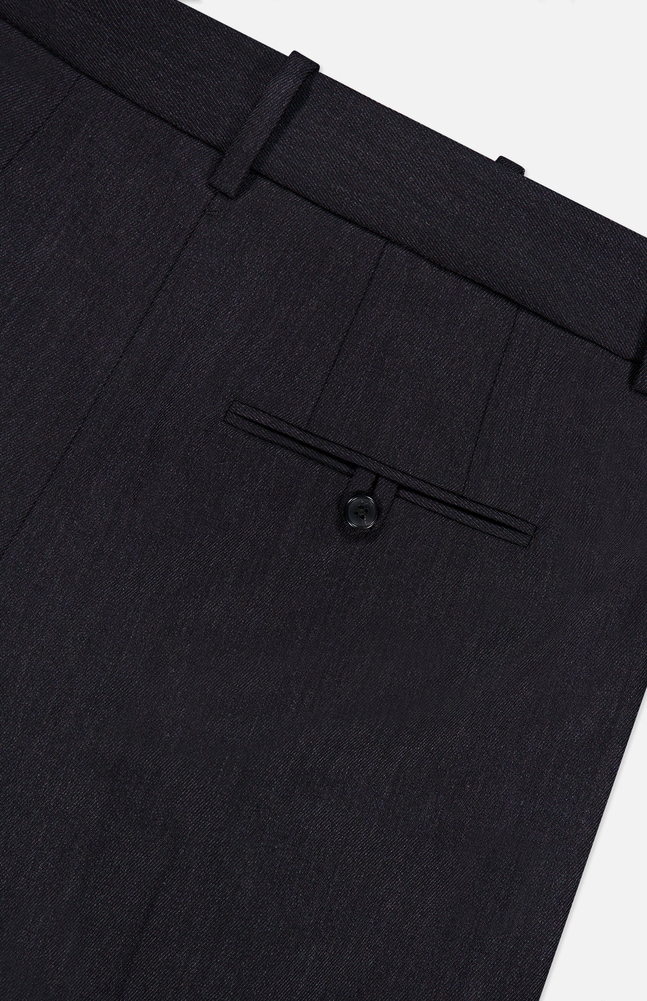 Close-up of the TWP Ivy Pleated Trouser Pant, crafted from dark Italian wool, featuring a waistband with belt loops and a single back pocket with button closure—an ideal choice for refined women’s workwear.
