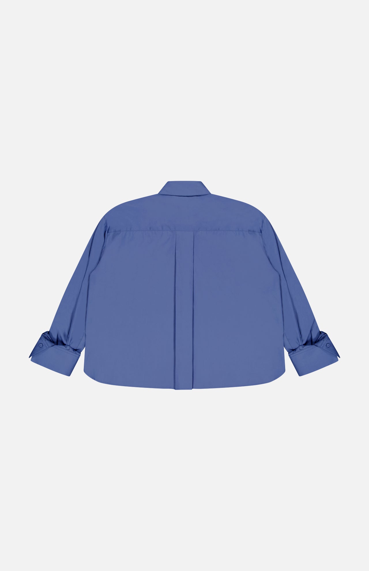The TWP J.D.S Cropped Shirt is a blue women’s work shirt with a boxy fit, box pleat, and buttoned cuffs, shown from the back and laid flat on a white background.