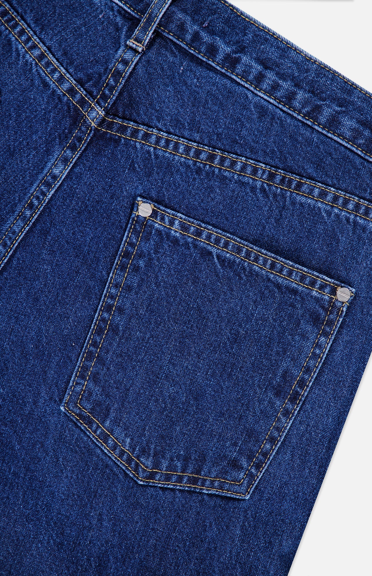 Close-up of the back pocket and waistband of the TWP Kent St Jean in Dark Stone, highlighting the detailed stitching and textured denim fabric.