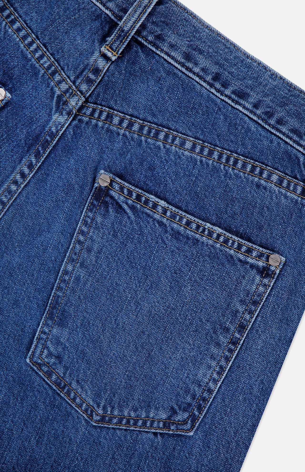 Close-up of the back pocket on the TWP Kent St Jean in Paris, highlighting intricate stitching details, a belt loop, and metal rivets at the pocket corners—a hallmark of this classic 5-pocket denim design.
