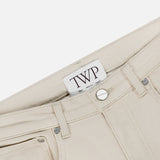 Close-up of the Kent St Pant in Bone, featuring a visible TWP brand label, silver button, belt loops, and pocket against a white background; these women’s straight leg pants offer a classic mid-rise fit.