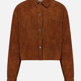 The TWP Little Big Joe Jacket is a brown suede, long-sleeve cropped shirt jacket featuring a collar, front buttons, single chest pocket, and straight hem. Displayed on a plain white background, this versatile womenswear piece combines style and practicality for effortless workwear.