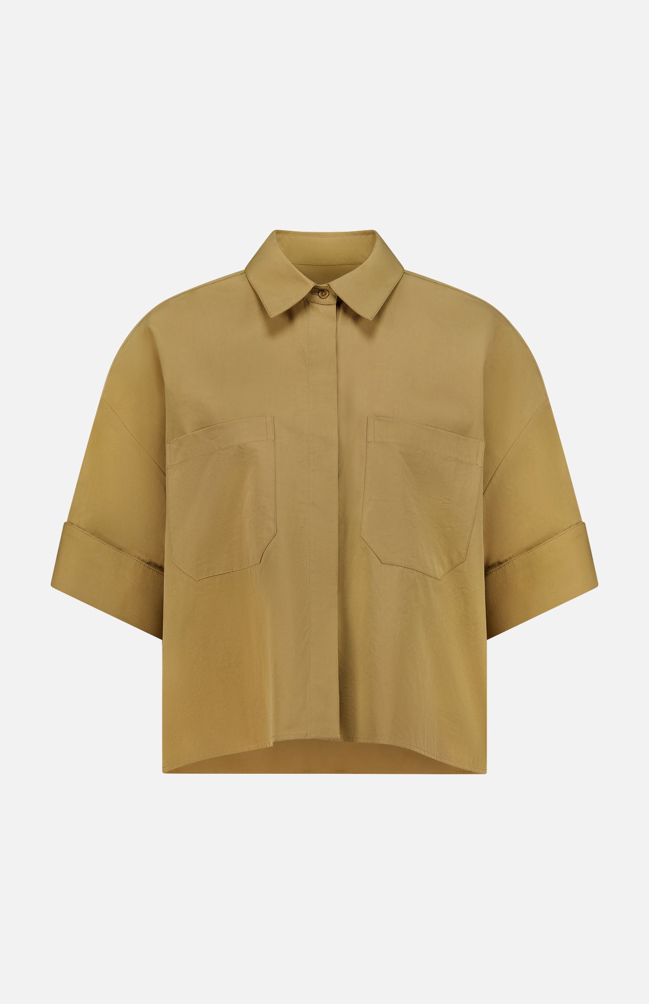 The My Newest Mistake Top by TWP is a short-sleeved Italian cotton blouse in light brown, featuring a collar, relaxed fit, two front chest pockets, and folded sleeve cuffs. Shown against a plain white background.
