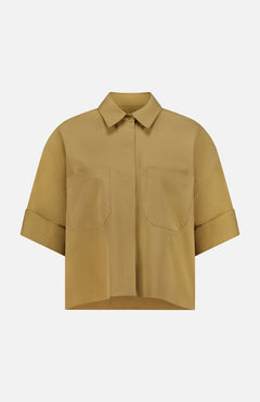 The My Newest Mistake Top by TWP is a short-sleeved Italian cotton blouse in light brown, featuring a collar, relaxed fit, two front chest pockets, and folded sleeve cuffs. Shown against a plain white background.