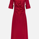 The TWP New Earl Wrap Front Dress is a knee-length, long-sleeve, red cotton shirt dress with a collared neckline, rolled cuffs, button-up front, and asymmetrical wrap style—ideal workwear for stylish, comfortable women.
