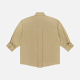 The TWP New Earl Asymmetric Button Front Shirt is a beige, long-sleeved Italian cotton shirt with buttoned cuffs and a central back seam, shown laid flat on a white background.