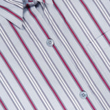 Close-up of the Next Ex Striped Blouse by TWP—a light blue button-up shirt featuring vertical stripes in white, gray, and red for a modern update to women’s workwear. The blouse has a folded collar and a pocket on the right side, combining style with practicality. A label reading TWP is visible inside the collar.
