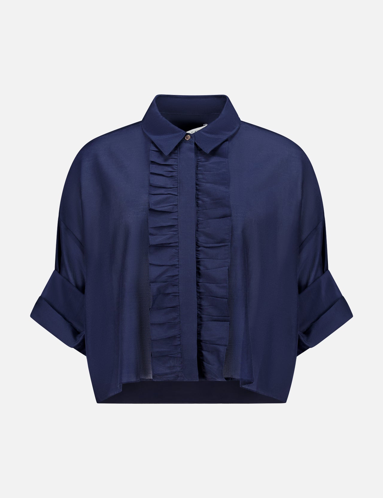 The TWP Next Ex Ruffle Blouse is a dark blue, short-sleeve button-up with a collared neckline, front ruffles, rolled cuffs, and a cropped boxy fit—ideal workwear for women. Shown against a plain white background.
