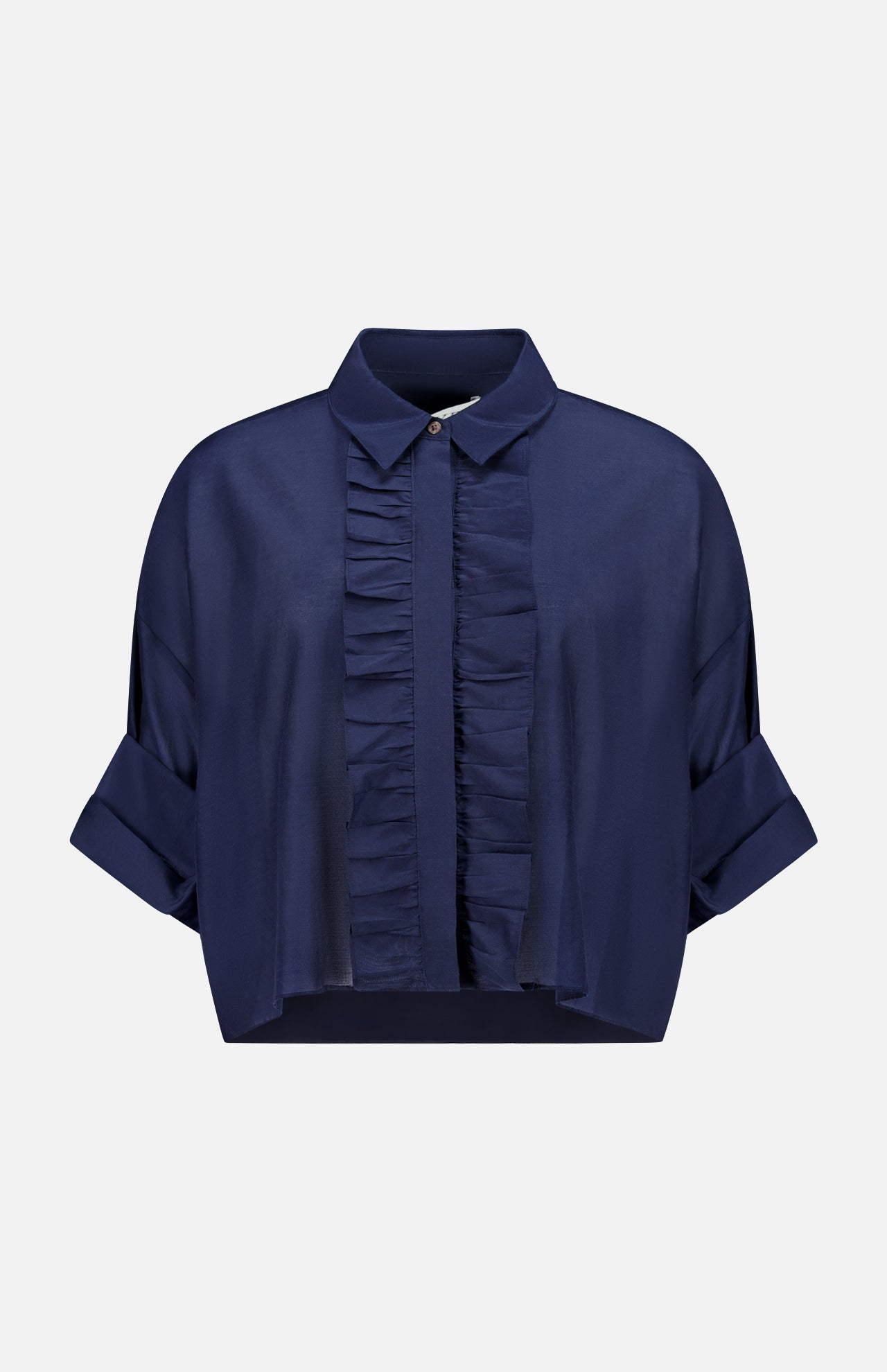 The TWP Next Ex Ruffle Blouse is a dark blue, short-sleeve button-up with a collared neckline, front ruffles, rolled cuffs, and a cropped boxy fit—ideal workwear for women. Shown against a plain white background.