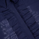 Close-up of the TWP Next Ex Ruffle Blouse in dark blue with a sheer finish, ruffled placket, and pointed collar. The TWP label is visible at the neckline—a stylish workwear choice for women.