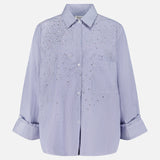 The TWP Next Morning Shirt with Crystals is a light purple, oversized Italian cotton button-down featuring a collar, front pocket, and sparkling crystal embellishments on the chest and shoulders.