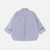 The TWP Next Morning Shirt with Crystals is shown flat in light blue, featuring long sleeves, a relaxed fit, classic collar, center back pleat, and unbuttoned cuffs. Crafted from Italian cotton with an oversized silhouette.