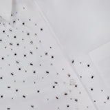 Close-up of the TWP Next Morning Crystal Shirt, an oversized white shirt expertly crafted from fine Italian cotton. The design is adorned with small, reflective silver crystal embellishments concentrated mostly on one side, and features classic buttons, a visible collar, and subtle sparkling details for an elevated finish.